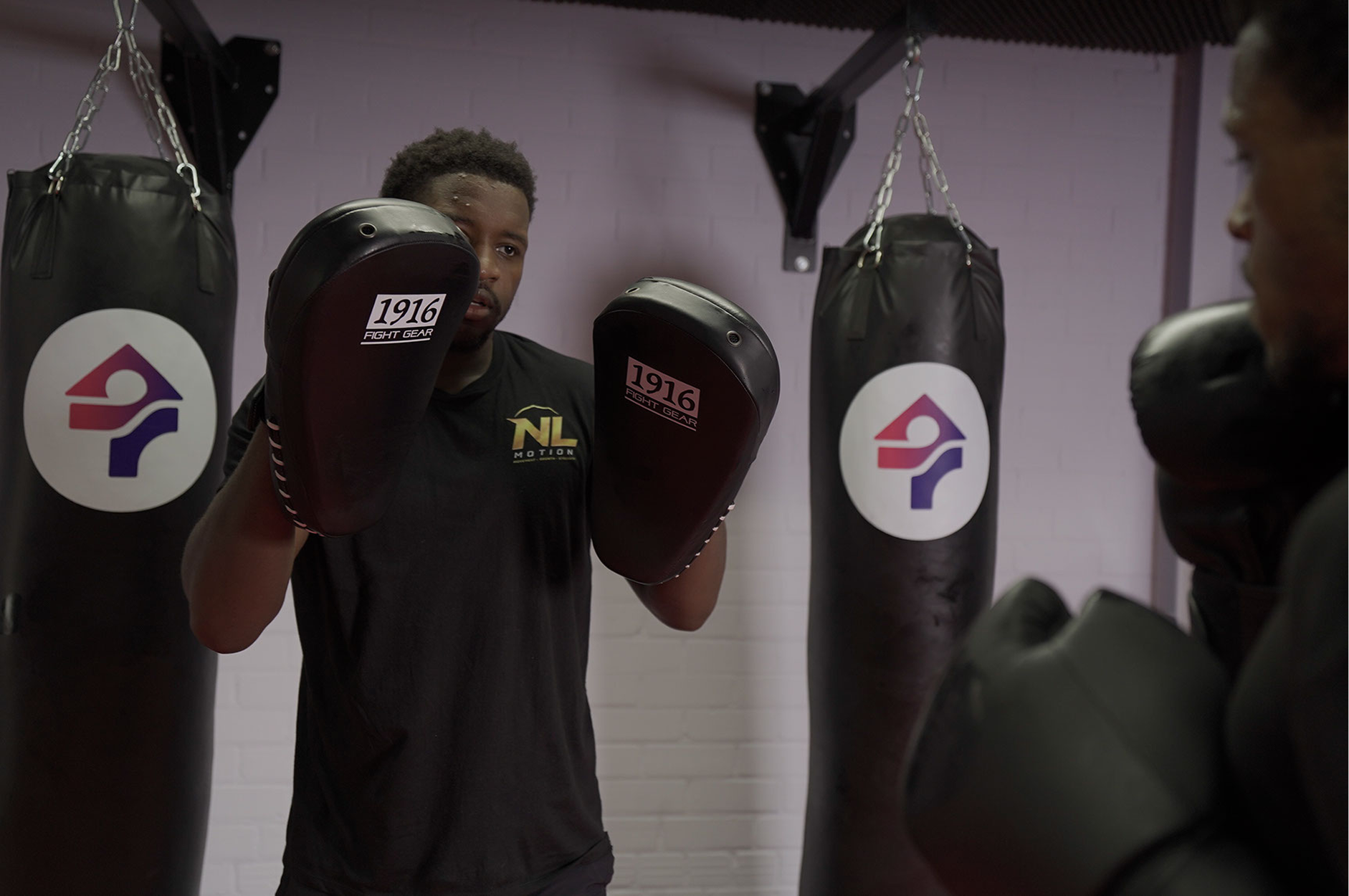Nathan houdt de pads vast tijdens techniektraining